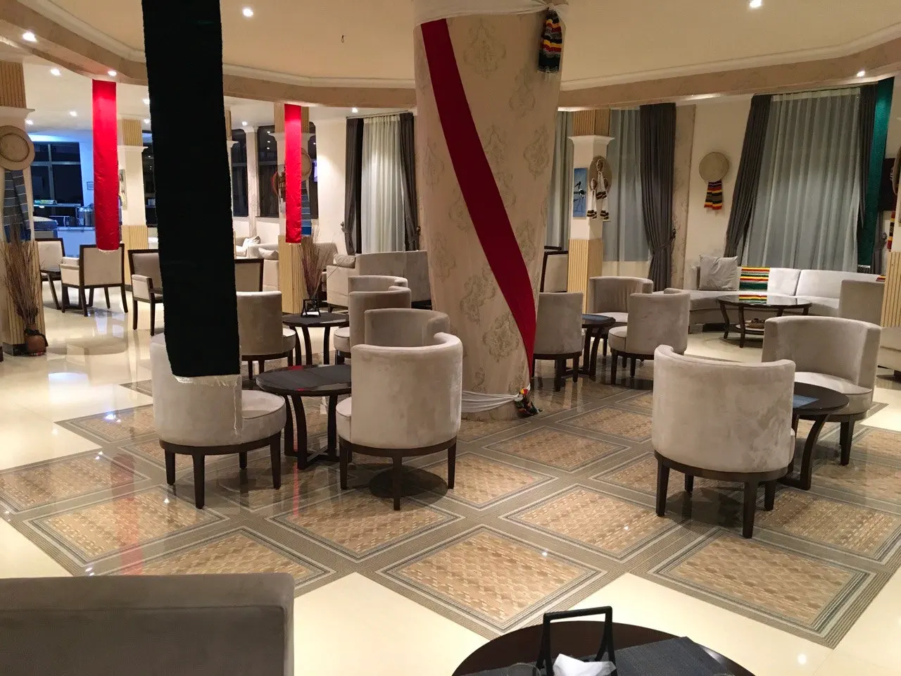 Lounge seating with round tables and armchairs on a patterned tile floor