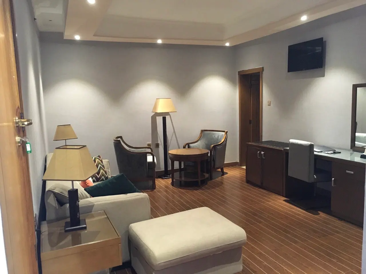Suite sitting area with a sofa, armchairs, a footstool and a desk