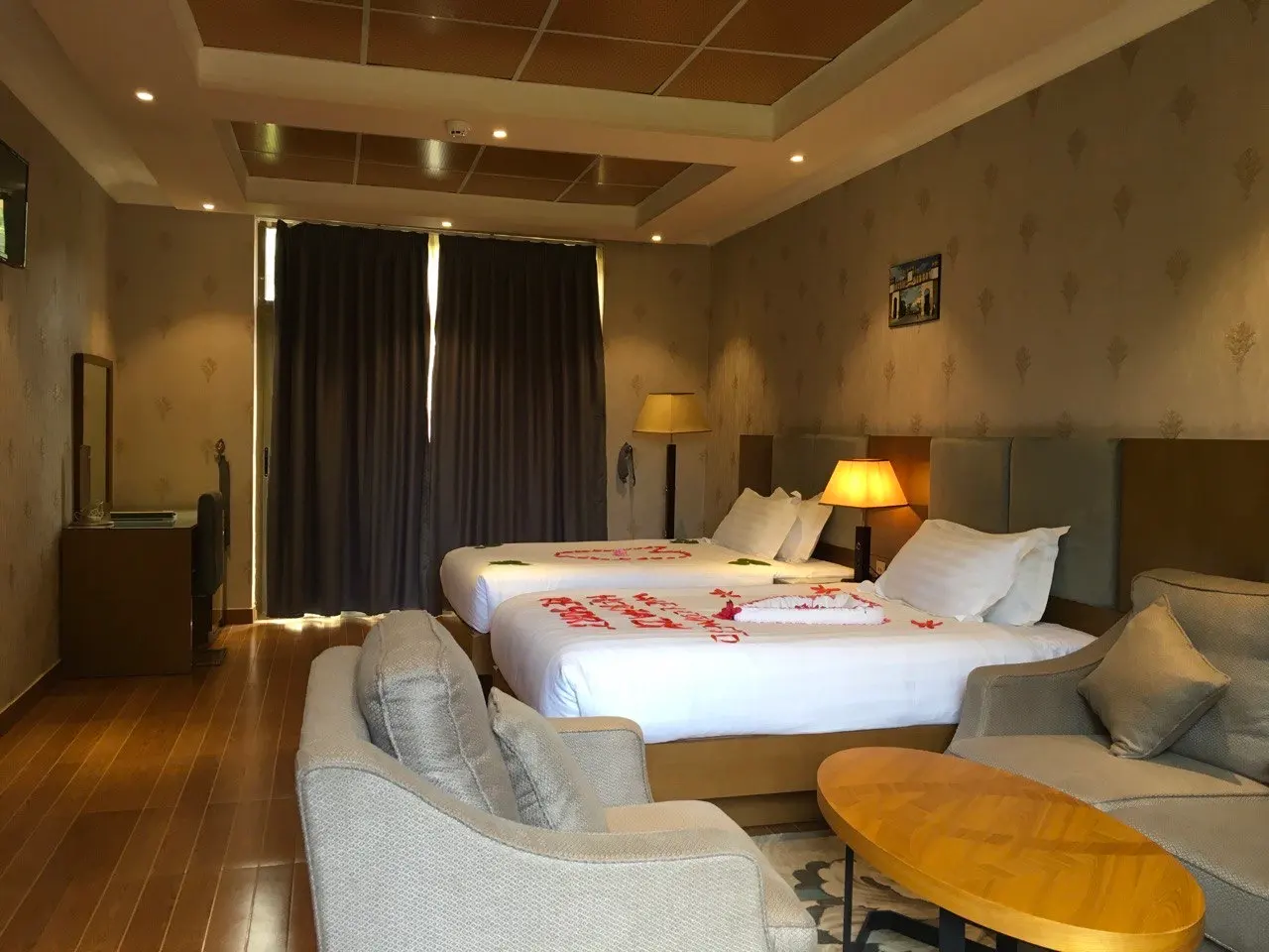 Semi-suite twin room with two beds dressed with rose petals and an armchair