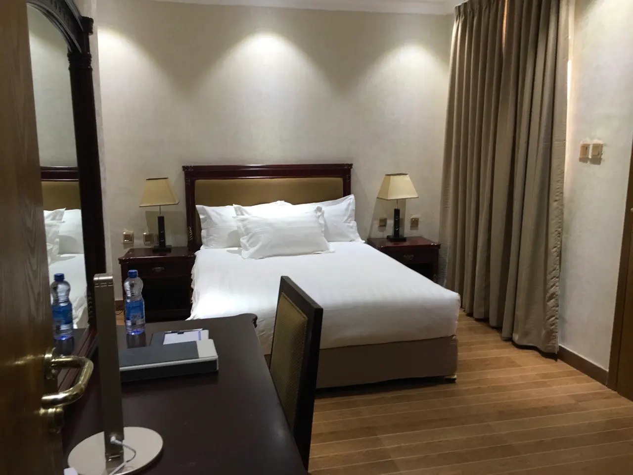 Standard room with a double bed, a desk and a mirror