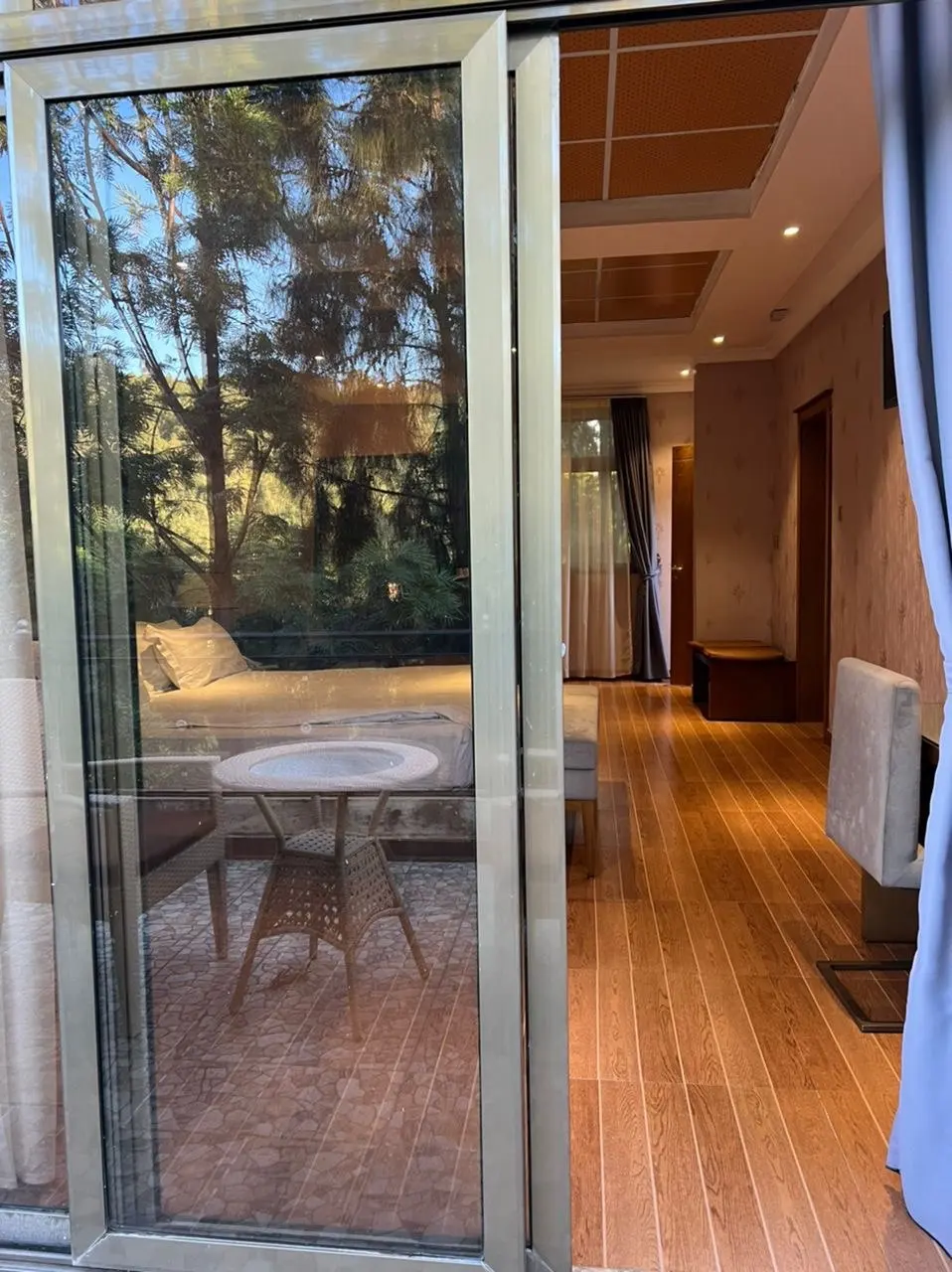 Sliding glass door opening from a room onto a terrace with a small table